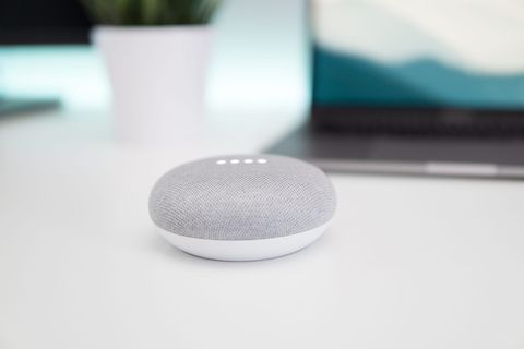 打开白色表面上的灰色和白色 Google Home Mini 扬声器