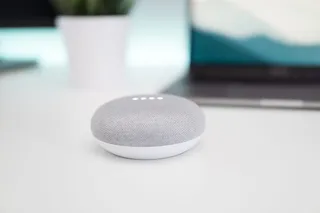 打开白色表面上的灰色和白色 Google Home Mini 扬声器