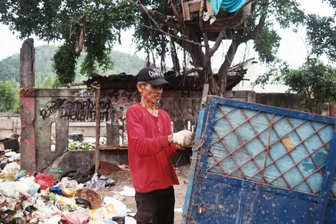穿红色长袖衬衫固定蓝色大门的男子 穿红色长袖衬衫固定蓝色大门的男子