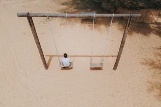 男子坐在秋千上]