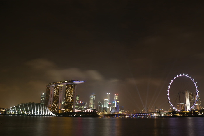 夜间水体和城市建筑物附近的发光摩天轮