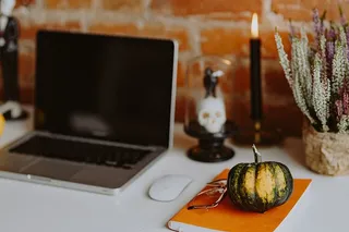 带笔记本电脑和万圣节装饰的桌子