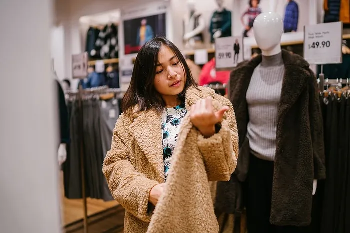 一名女子在人体模型旁查看价格