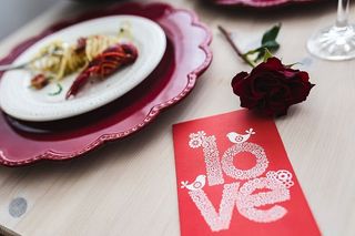 精美的晚餐，搭配海鲜意大利面、小龙虾和红酒，餐桌上装饰着玫瑰