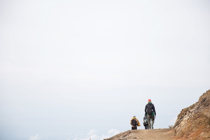 背着背包在碎石山上行走的徒步旅行者