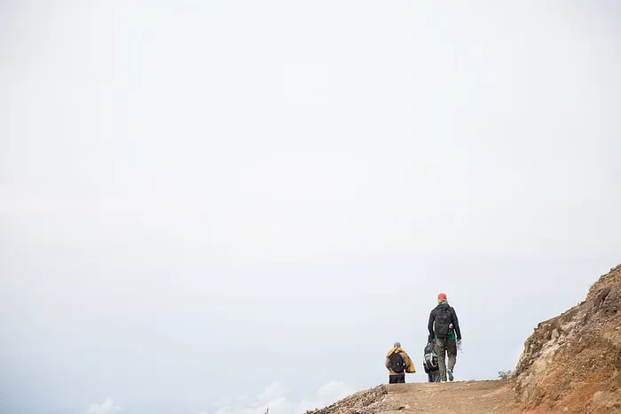 背着背包在碎石山上行走的徒步旅行者