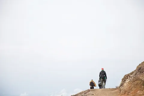 背着背包在碎石山上行走的徒步旅行者