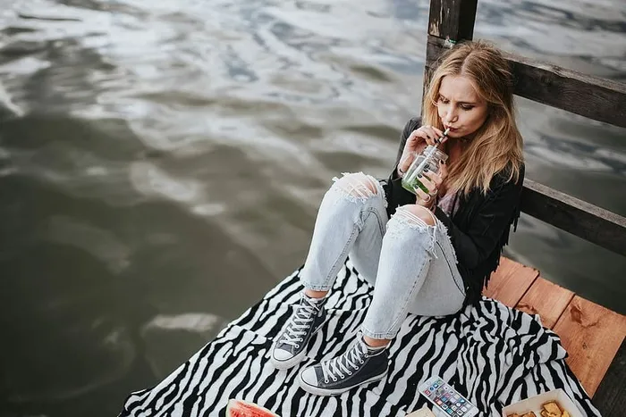 金发女人在木码头吃健康零食