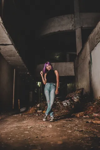 身穿黑色无袖衬衫和蓝色旧牛仔裤的女子浅焦照片