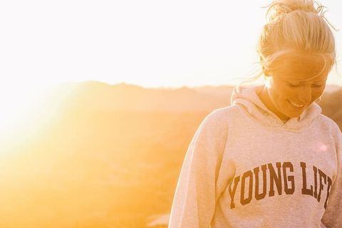 一个女孩在日落时被美丽的夏日阳光捕捉