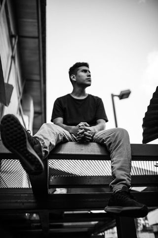 男人坐着的灰度照片