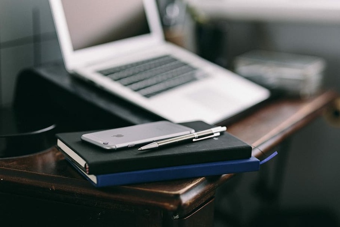 优雅的工作空间，配备Macbook、iPhone、名片和笔记本电脑