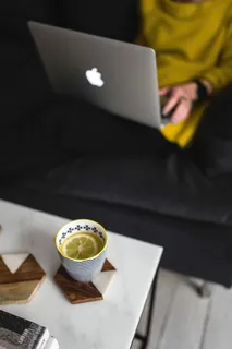 坐在沙发上用笔记本电脑工作的年轻女子