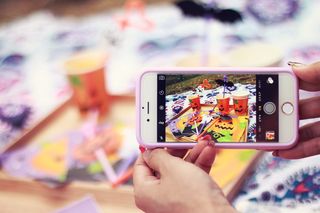 拿着金色iPhone 6和粉色手机壳的人为jack-o打印杯拍照