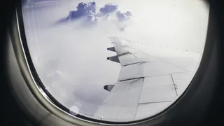 飞行中飞机机翼在云层上的建筑摄影