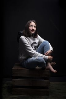 一名女子坐在棕色木箱上的照片