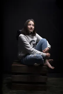 一名女子坐在棕色木箱上的照片 一名女子坐在棕色木箱上的照片