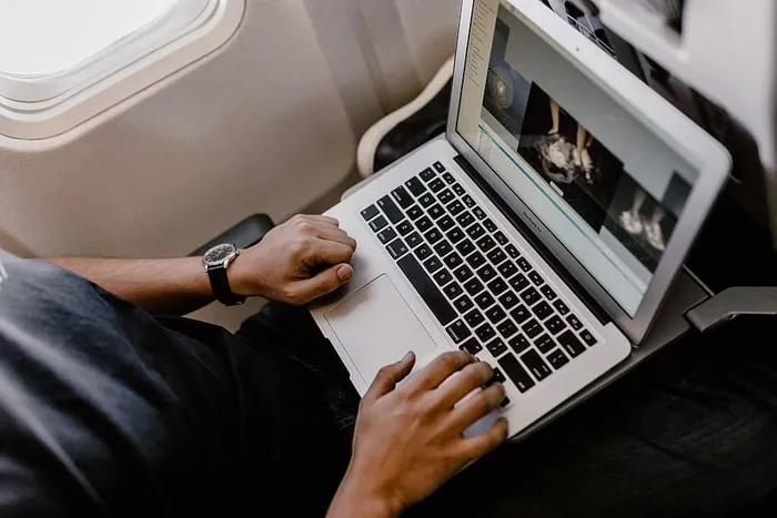 坐在飞机里的一个拿着笔记本的面目全非的男人