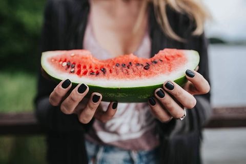 金发女人在木码头吃健康零食