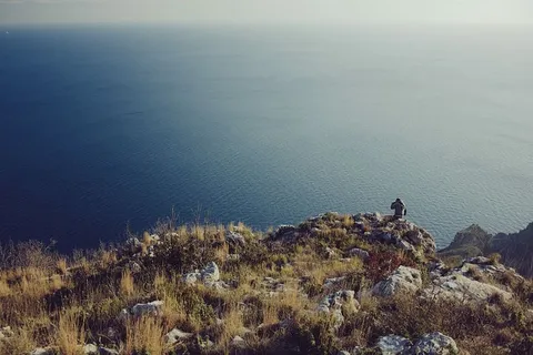 阴天,站在悬崖附近观看水体的人 阴天,站在悬崖附近观看水体的人
