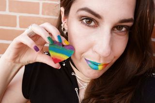 身穿黑色衬衫的女子手持条纹心形装饰