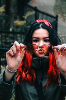 手持心形镜框太阳镜的女子