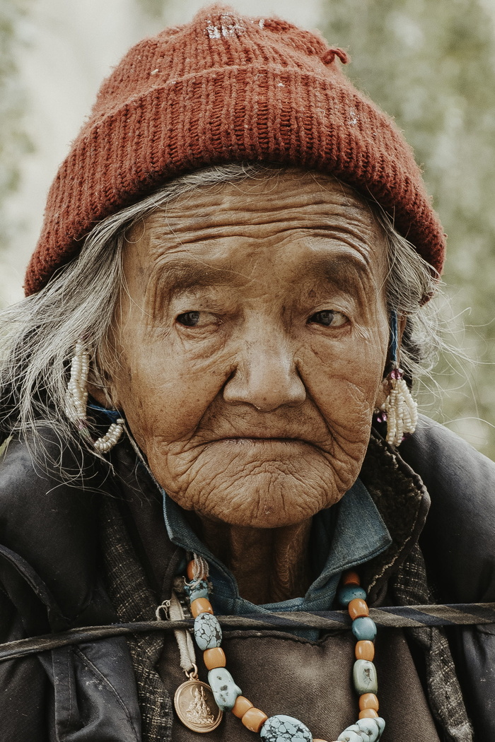 一位戴红色针织帽的老妇人的特写照片