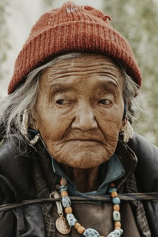 一位戴红色针织帽的老妇人的特写照片