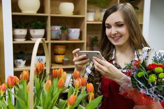 拍摄橙色郁金香照片的女人