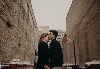 站在棕色混凝土建筑之间的夫妇