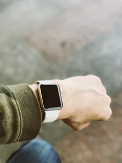 佩戴银白金苹果手表和白色运动乐队的人 佩戴银白金苹果手表和白色运动乐队的人