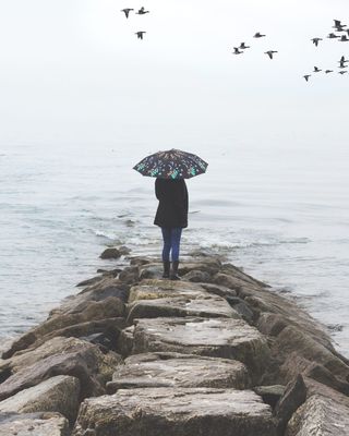 在水体附近持伞者的照片