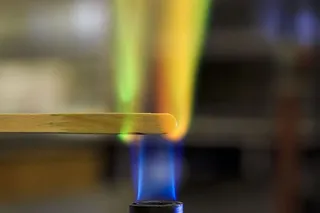 铜溶液在本生灯火焰中的木夹板上燃烧。