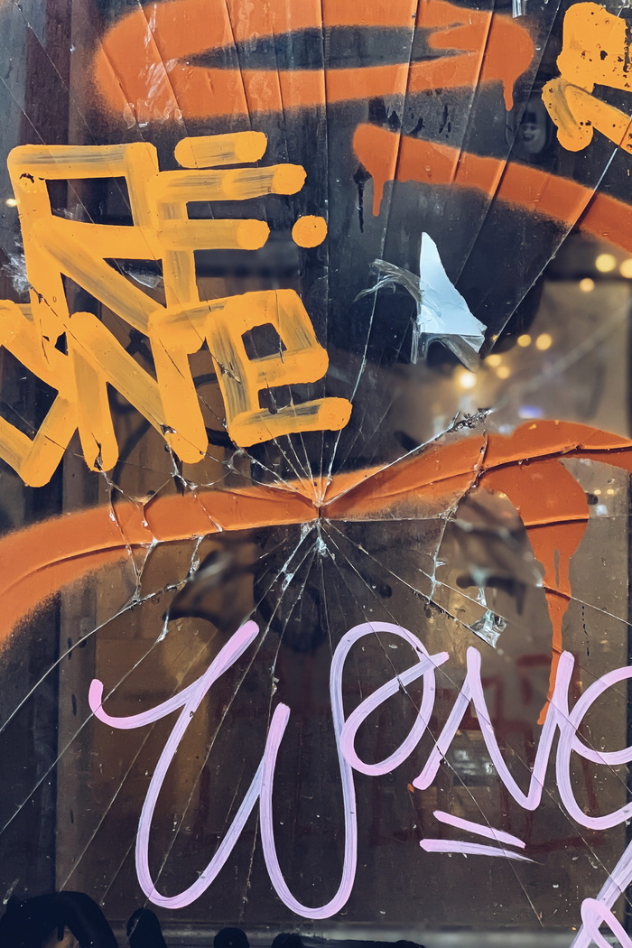 带橙色和黄色文字漆的破裂玻璃