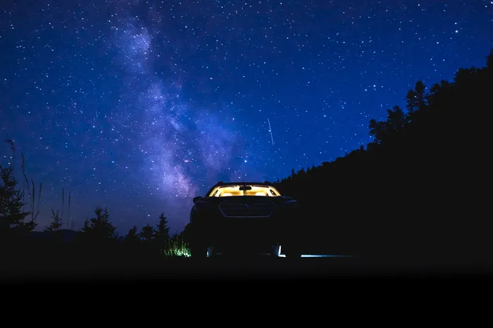 停在星空下的森林里的汽车