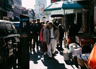 穿着米色夹克在街上行走的男子