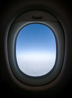 从飞机的窗口可以看到晴朗的天空