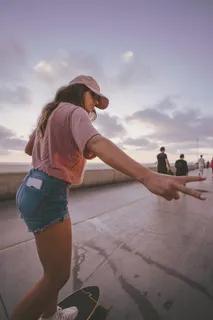 白天在人行道上玩滑板的女人 白天在人行道上玩滑板的女人