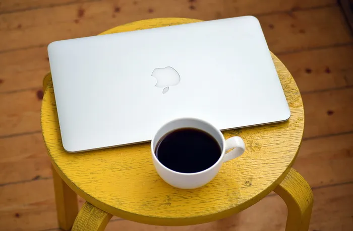 白色杯子旁的银色Macbook