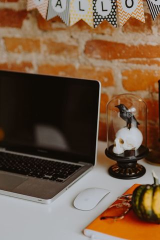 带笔记本电脑和万圣节装饰的桌子
