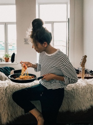 穿着黑白条纹衬衫的女人在吃锅里的食物