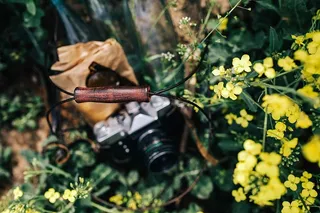 在盛开的油菜地里拿着老式相机的女人