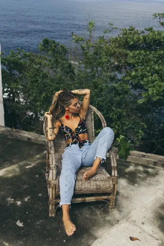 坐在棕色柳条扶手椅上的女人