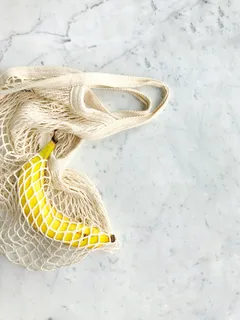 白色针织袋中的熟香蕉 白色针织袋中的熟香蕉