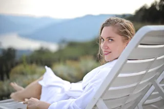 穿着白色浴袍躺在台球椅上微笑的女人的选择性聚焦摄影