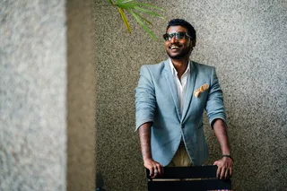 黑色木椅前穿着蓝色正式夹克的男子