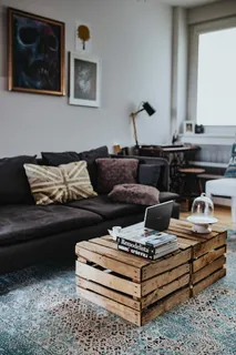 设计师设计的客厅内部有一张木箱桌和一块浅蓝色地毯