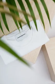 木制桌子上的白色圆领衬衫 木制桌子上的白色圆领衬衫