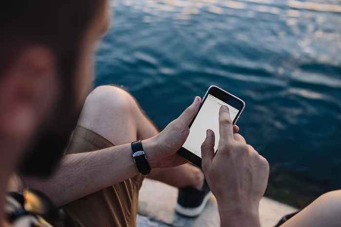 在海边，人们手里拿着手机