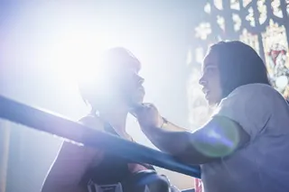 在拳击台上固定拳击头盔的人